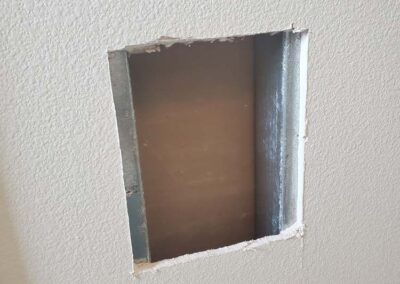 a rectangular cut in drywall made to fix wall damage done by mckeague drywall in hawaii