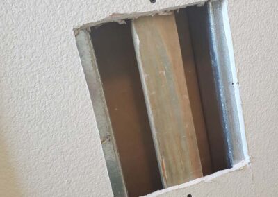 drywall damage repaired by screwing wood inside the hole to support a drywall patch done by mckeague drywall in hawaii