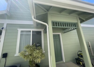 AFTER - exterior painting of a green house in Hawaii by Mckeague Drywall showing the front door