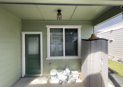 AFTER - exterior painting of a green house in Hawaii by Mckeague Drywall showing the back door