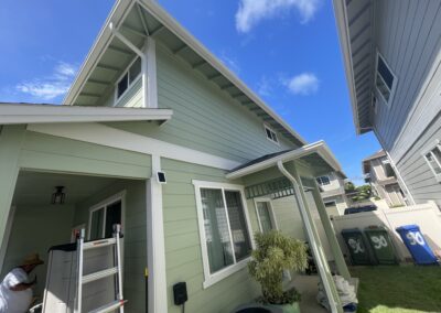 AFTER - exterior painting of a green house in Hawaii by Mckeague Drywall showing the back and side doors