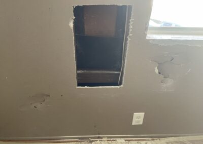 photo showing how Mckeague Drywall LLC repairs damaged drywall with one damaged area of the wall already removed and several more left to go