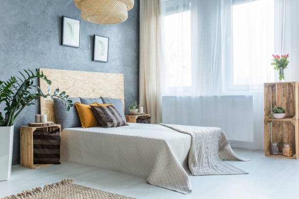 Grey bedroom with crate furniture, double bed and plants