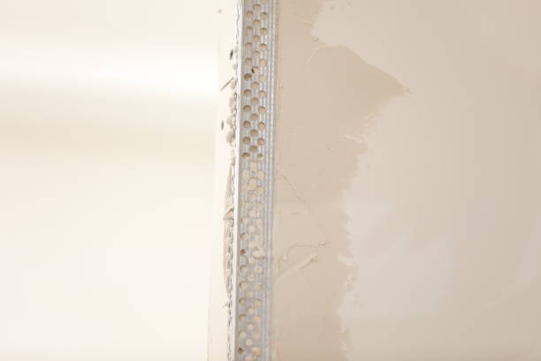 The worker set the metal wall profile in the new flat. Plasterboard metal profiles. Gypsum board installation background. Metallic material for building walls.